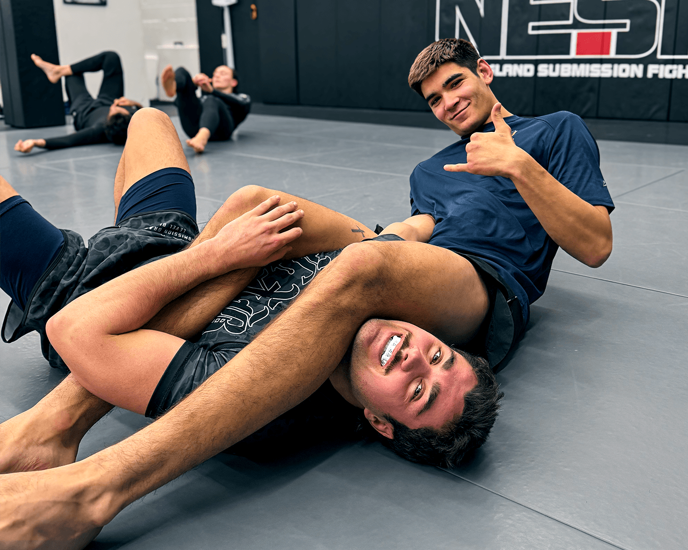 Students drilling an armbar and smiling.